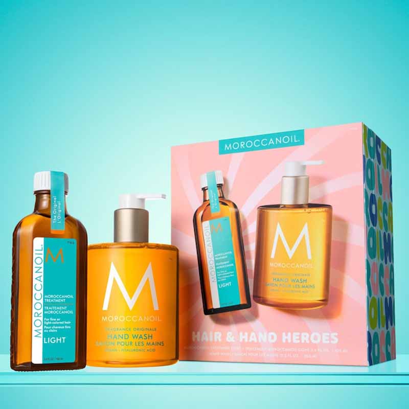 Moroccanoil Hair and Hand Heroes Light Gift Set pink box with turquoise background behind the set