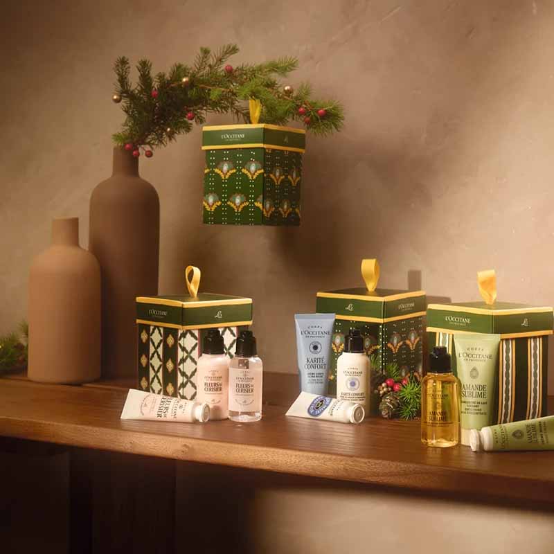 L'Occitane Shea Butter Christmas Ornament Collection of ornament gift sets with an example of one hanging on the tree