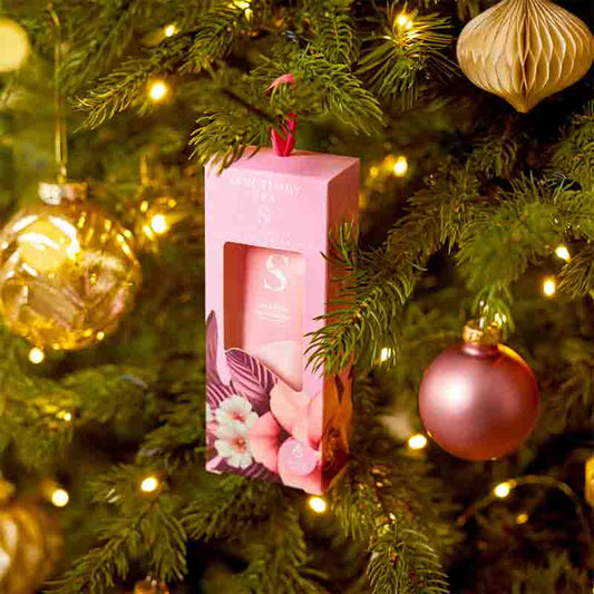 Sanctuary Lily & Rose Natural Oils Hand Cream shown hanging on a tree