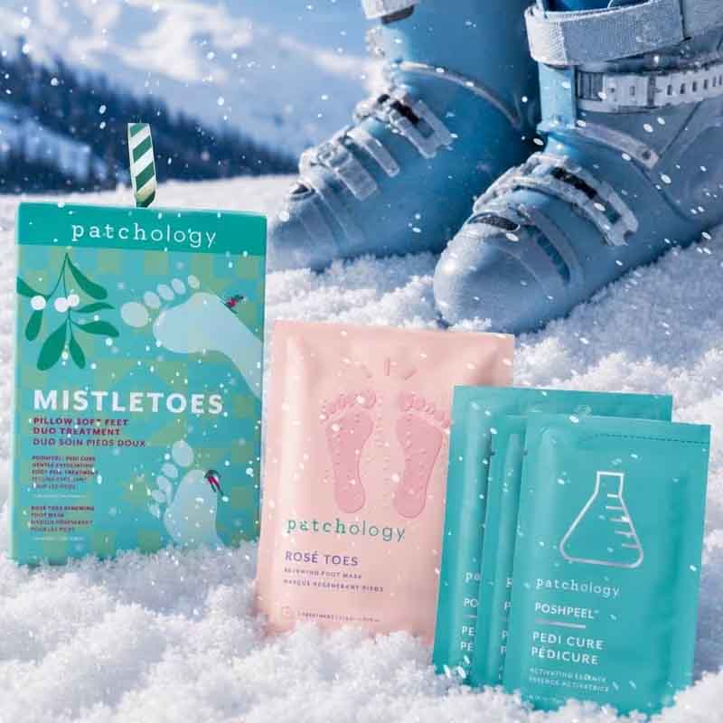 Patchology Mistletoes Gift Set stylised image of snow boots and 4 packets in gift set sitting in the snow