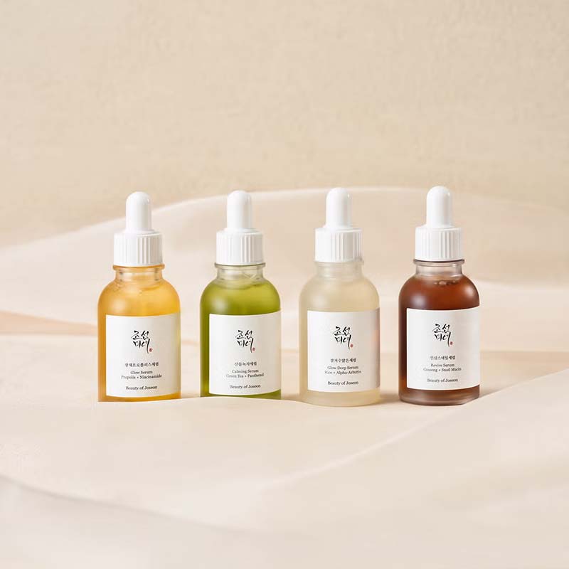 Collection of the Beauty Of Joseon Serums sitting on a bed of linen sheets
