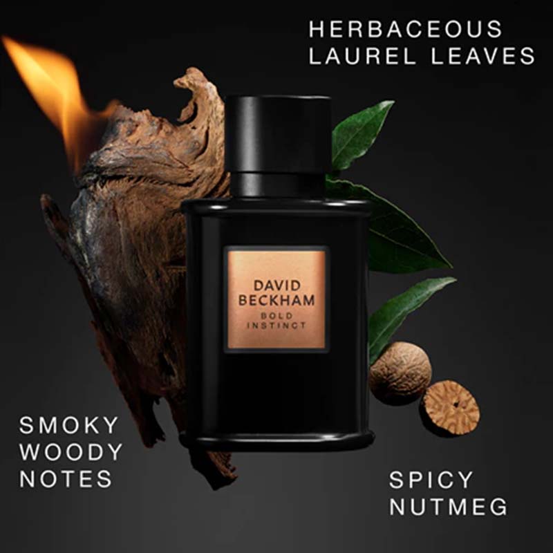 David Beckham Bold Instinct perfume bottle in a matte black finish, styled with a burning piece of wood, green leaves, and whole nutmegs on a dark background. White text reads 'HERBACEOUS LAUREL LEAVES', 'SMOKY WOODY NOTES', and 'SPICY NUTMEG'.