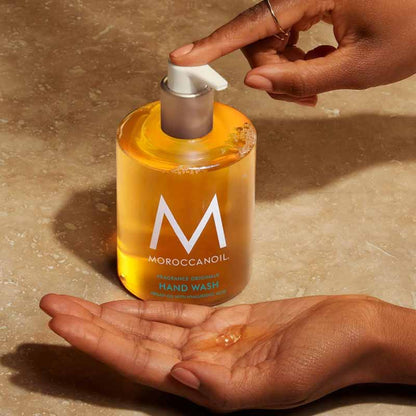 Moroccanoil Hair and Hand Heroes Mist Gift Set hand wash being pumped into a hand stylised image