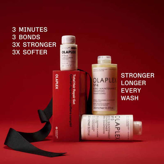 Ola Plex Total Hair Repair Set featuring a red box, shampoo bottle, conditioner bottle, and a black ribbon on a dark red background with promotional text.
