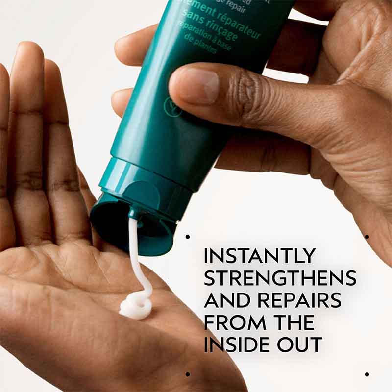 Hand holding a teal bottle with white cream being applied to another hand, on a light gray background.