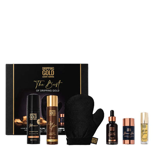 Dripping Gold self tan gift set featuring a black and gold presentation box, a black bottle, a gold-capped treatment bottle, a black glove, a dark amber dropper bottle, a copper-toned cap, and a small gold-capped vial, arranged on a white background.