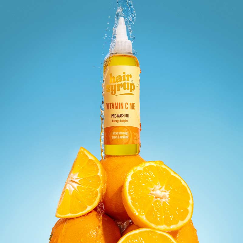 Hair Syrup Vitamin C Me Pre Wash Hair Oil For Damaged Hair 100ml sitting on Orange Pyramid With Blue Sky Behind Image
