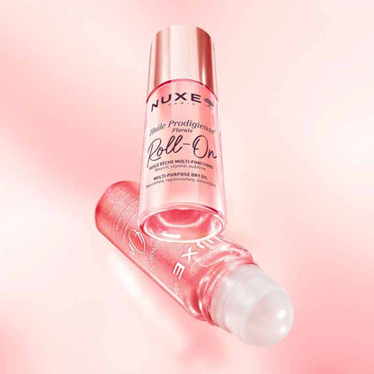 NUXE Huile Prodigieuse Floral Gold Shimmer Multi-Purpose Dry Oil image of the shimmer bottle sitting beneath the non shimmer bottle, the image shows the roll on application tool with a pale pink background