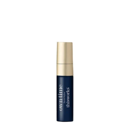 A small cylindrical cosmetic bottle with a dark navy blue body and a metallic gold cap, featuring white text that reads 'own time for thisworks' on a plain white background.